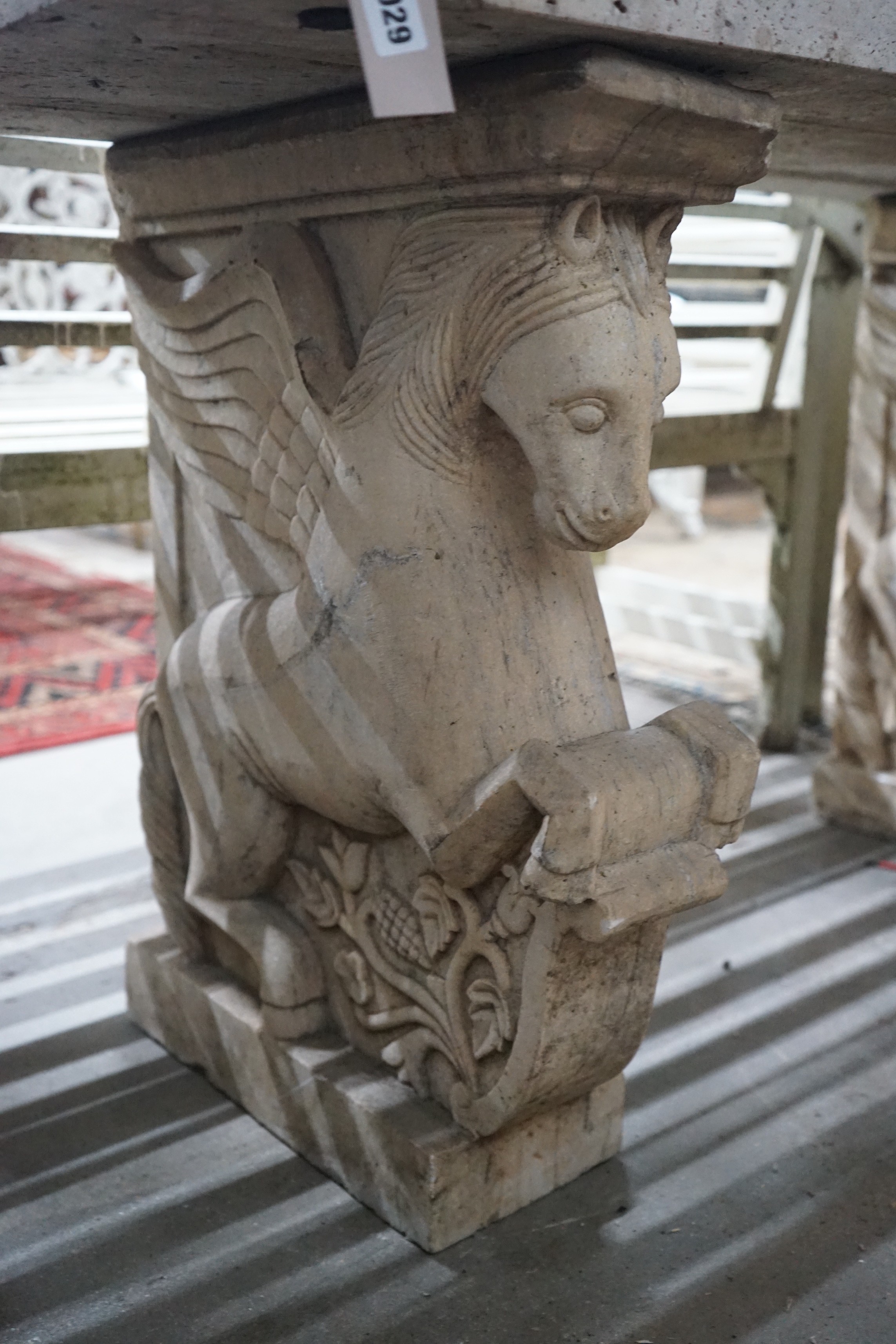 A carved stone Pegasus console table, width 127cm, depth 46cm, height 66cm